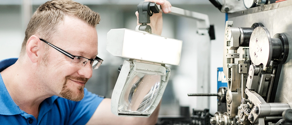 Mitarbeiter prüft eine Feder auf ihre Festigkeit und Funktionalität im Testbereich.